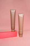 Airyday Bright Nights Sleep Mask in rose-gold tubes with pink lettering, shown beside a bright coral-red box.